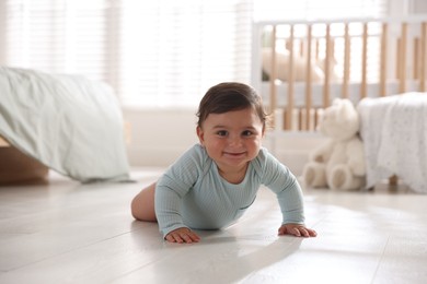Photo of Cute little baby crawling on floor at home