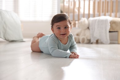 Photo of Cute little baby lying on floor at home