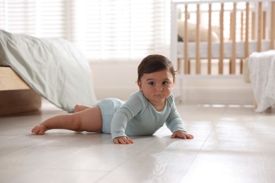 Photo of Cute little baby lying on floor at home, space for text