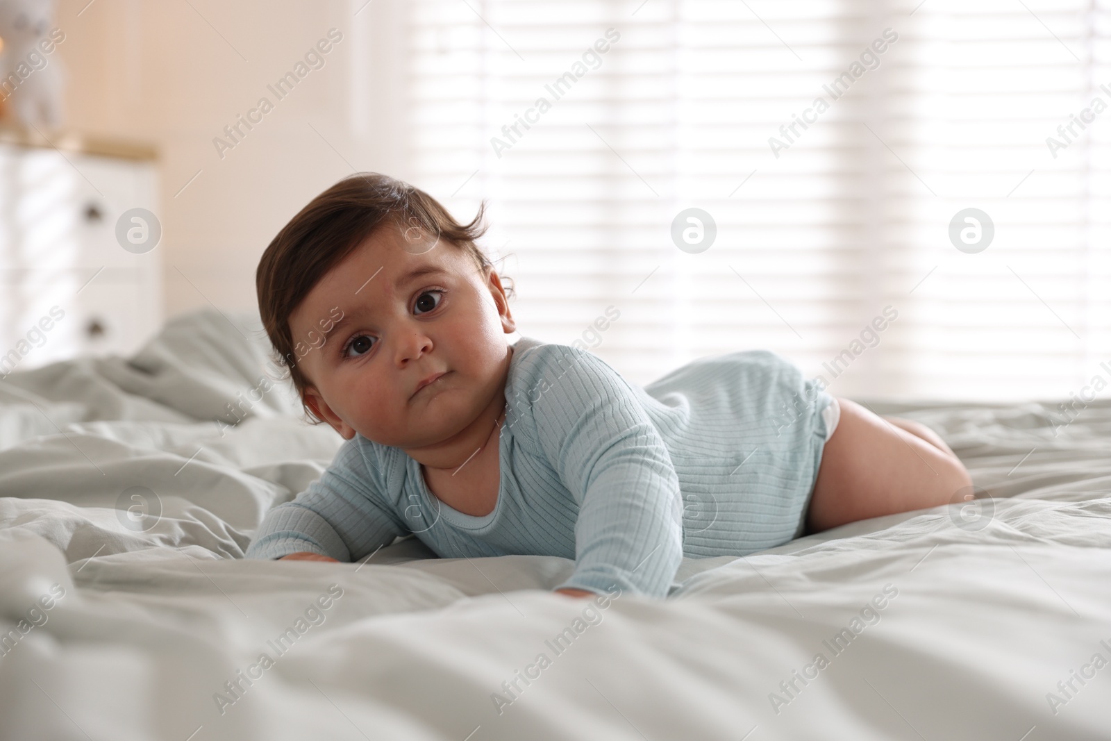 Photo of Cute little baby on bed at home