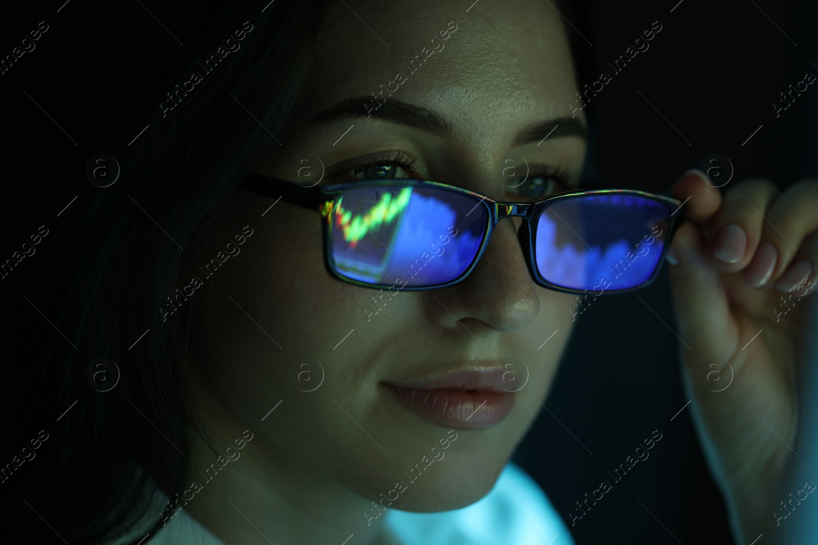 Young woman wearing glasses with reflection on dark background, closeup Photo of Young woman wearing glasses with reflection on dark background, closeup