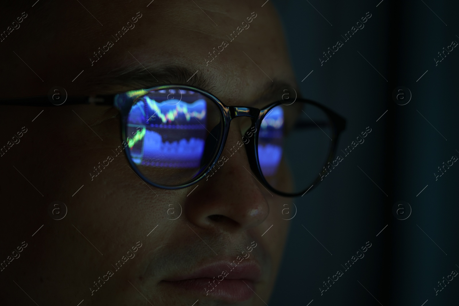 Young man wearing glasses with reflection on dark background, closeup Photo of Young man wearing glasses with reflection on dark background, closeup