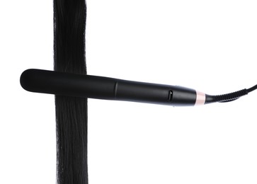 Photo of Straightener with black hair lock isolated on white