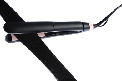 Photo of Straightener with black hair lock isolated on white
