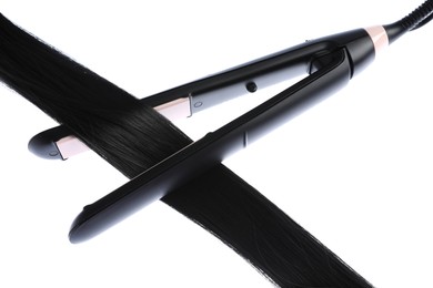 Photo of Straightener with black hair lock isolated on white