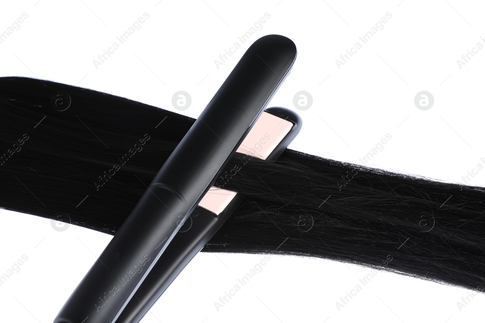 Straightener with black hair lock isolated on white Photo of Straightener with black hair lock isolated on white