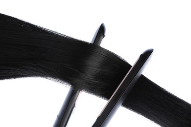 Photo of Straightener with black hair lock isolated on white