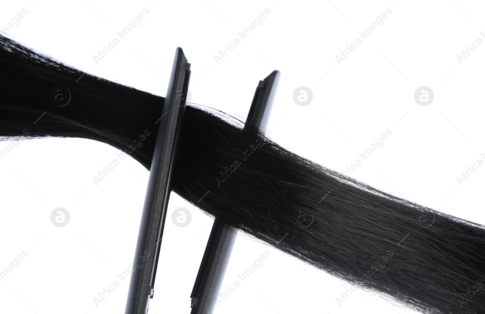 Photo of Straightener with black hair lock isolated on white