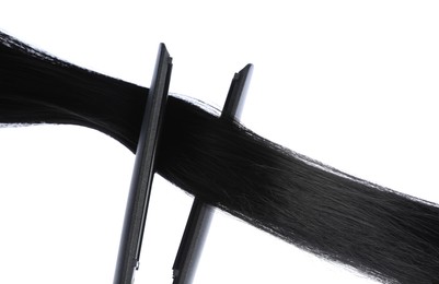 Photo of Straightener with black hair lock isolated on white