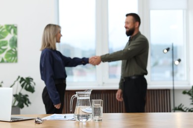 Photo of Business partners shaking hands in office, selective focus