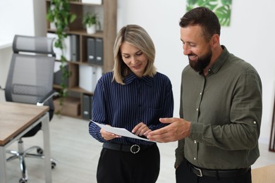 Photo of Smiling business partners working together in office