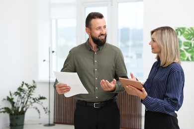 Photo of Smiling business partners with tablet working together in office