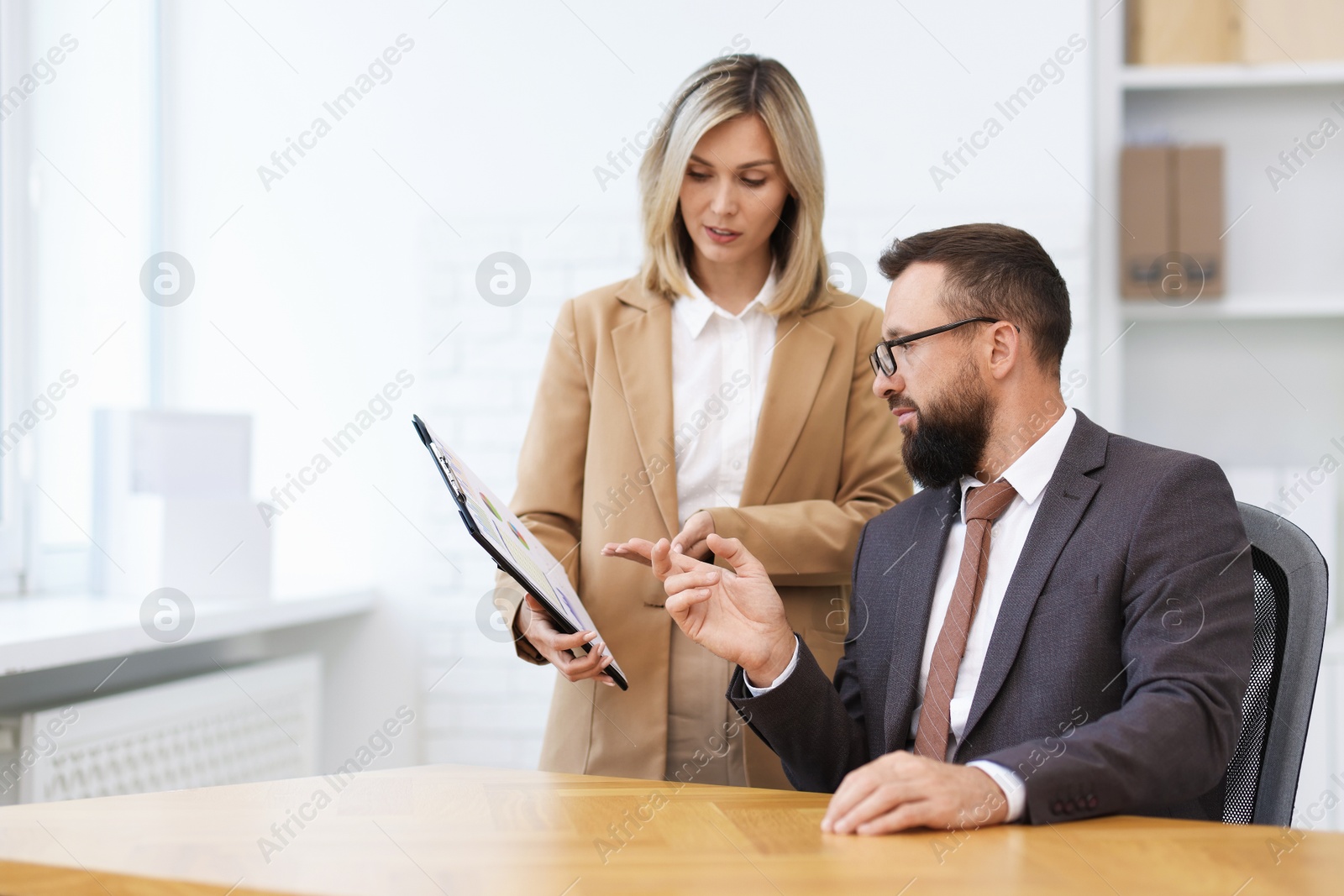 Photo of Business partners working with documents at table in office