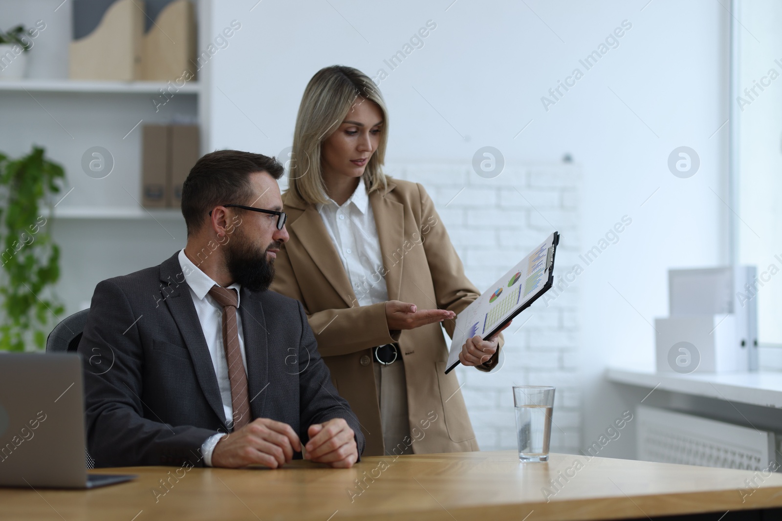 Photo of Business partners working with documents at table in office