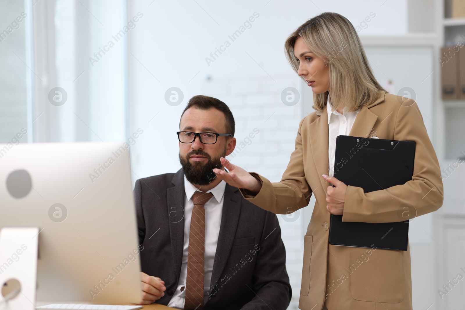 Photo of Business partners working with computer in office