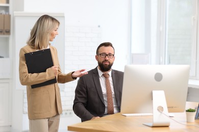 Photo of Business partners working with computer at table in office
