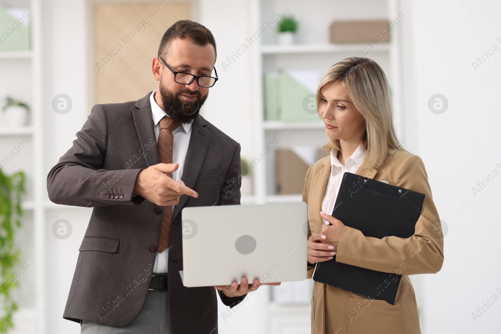 Business partners working with laptop in office Photo of Business partners working with laptop in office