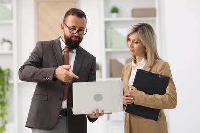 Photo of Business partners working with laptop in office