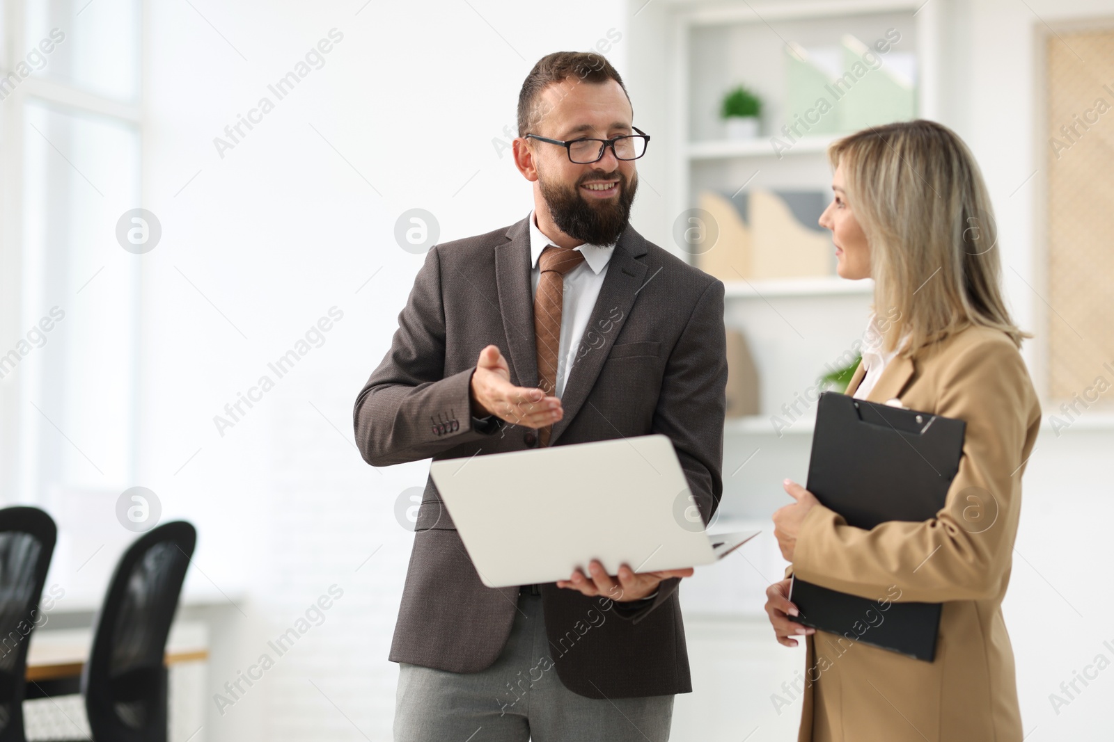 Business partners working with laptop in office Photo of Business partners working with laptop in office