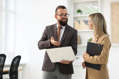Photo of Business partners working with laptop in office