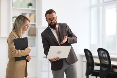 Photo of Business partners working with laptop in office