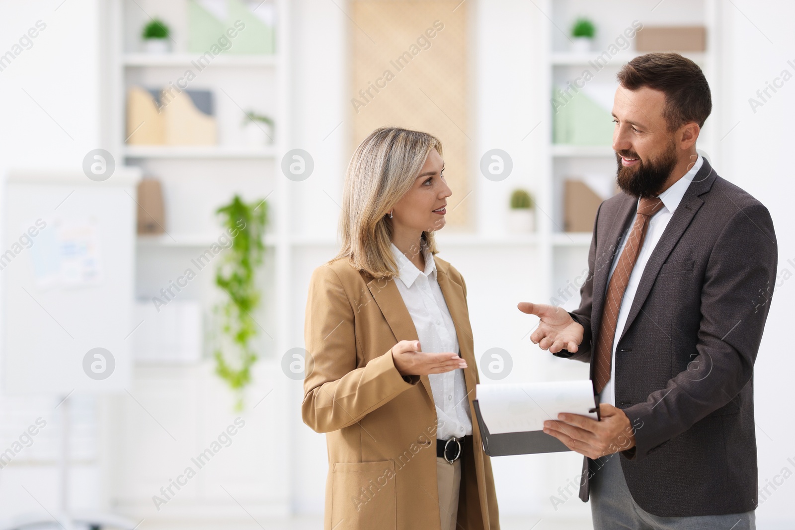 Business partners with documents talking during meeting in office. Space for text Photo of Business partners with documents talking during meeting in office. Space for text