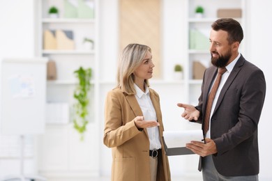 Photo of Business partners with documents talking during meeting in office. Space for text