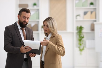 Photo of Business partners with documents during meeting in office. Space for text