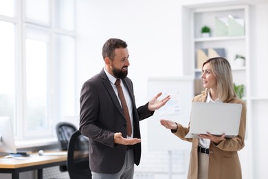 Photo of Business partners with laptop during meeting in office