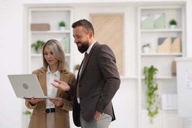Photo of Business partners working with laptop in office