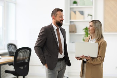 Photo of Business partners working with laptop in office