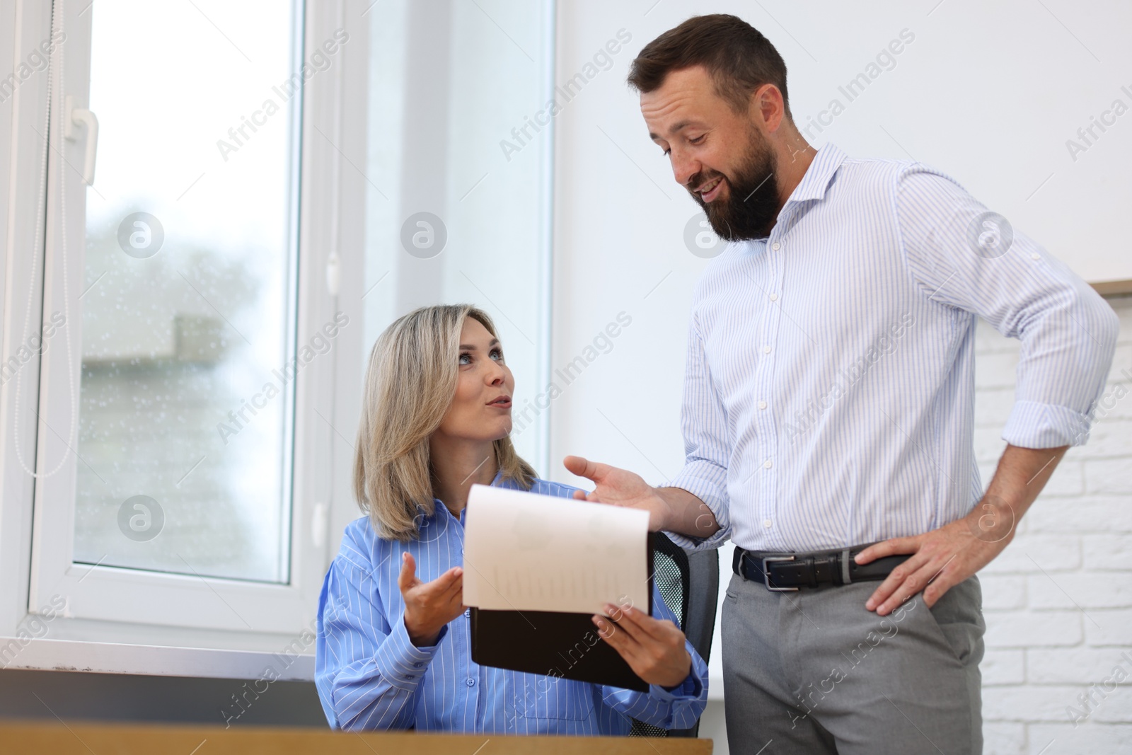 Photo of Smiling business partners working with documents in office, low angle view