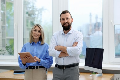 Photo of Portrait of smiling business partners with tablet in office