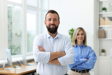 Photo of Portrait of smiling business partners with crossed arms in office