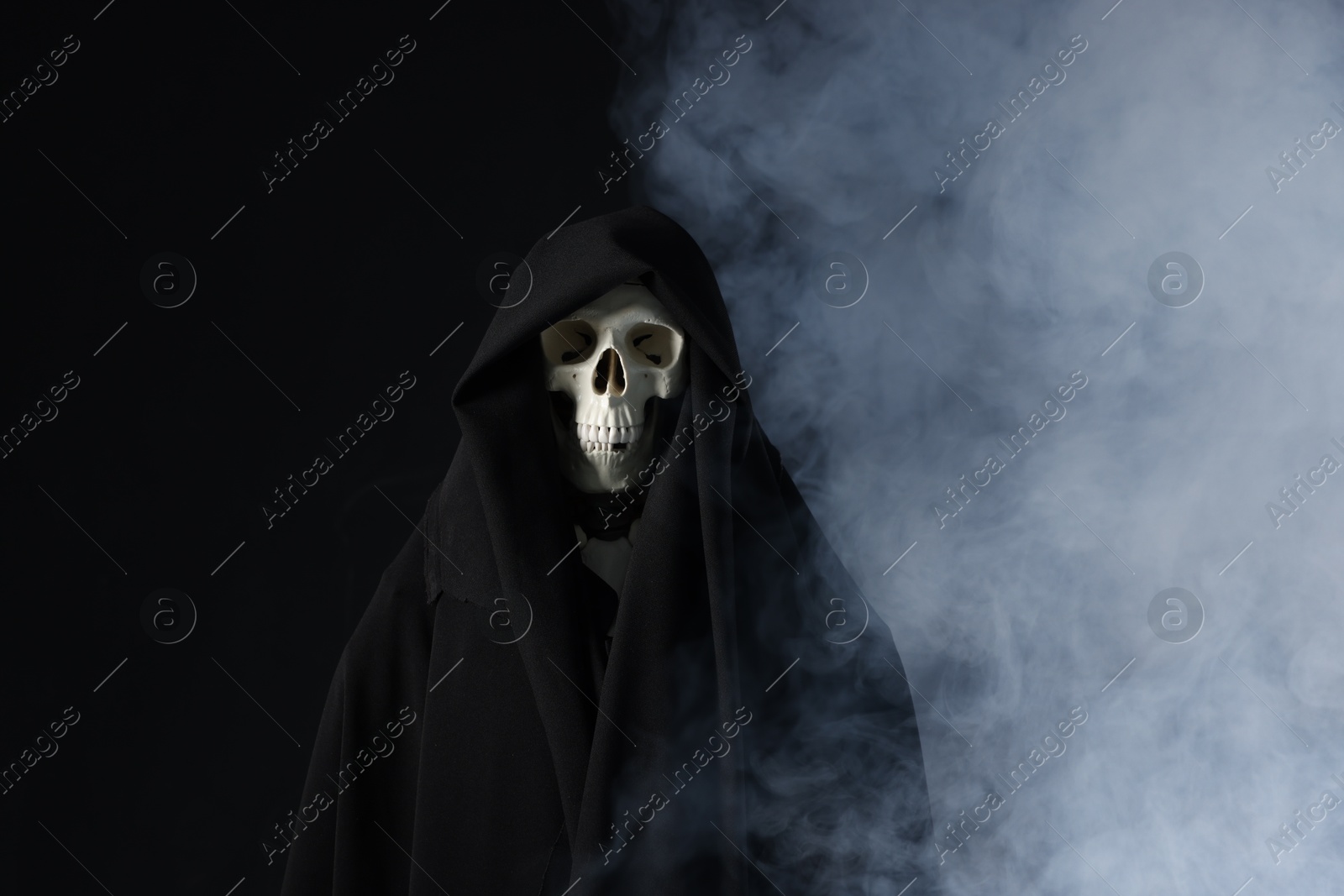 Creepy ghost. Skeleton covered with sheet in smoke on black background Photo of Creepy ghost. Skeleton covered with sheet in smoke on black background