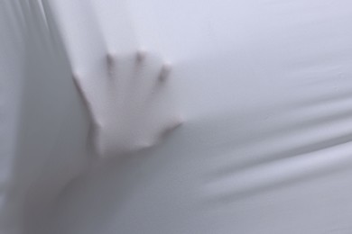 Photo of Creepy ghost behind white sheet, closeup. Space for text