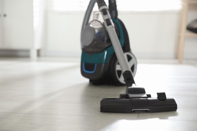 Photo of One vacuum cleaner on floor indoors. Household appliance