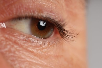 Photo of Man with beautiful brown eyes on grey background, macro view