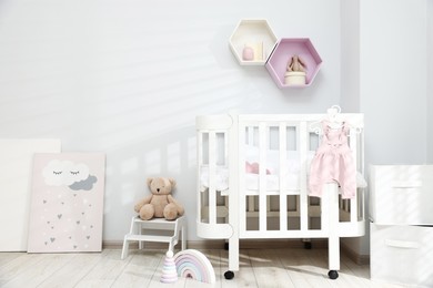 Photo of Stylish baby room interior with comfortable crib and other furniture