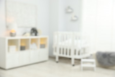 Photo of Baby room interior with stylish crib and other furniture, blurred view