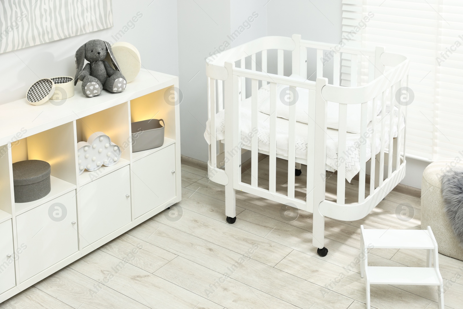 Beautiful baby room interior with stylish crib, other furniture and toys Photo of Beautiful baby room interior with stylish crib, other furniture and toys