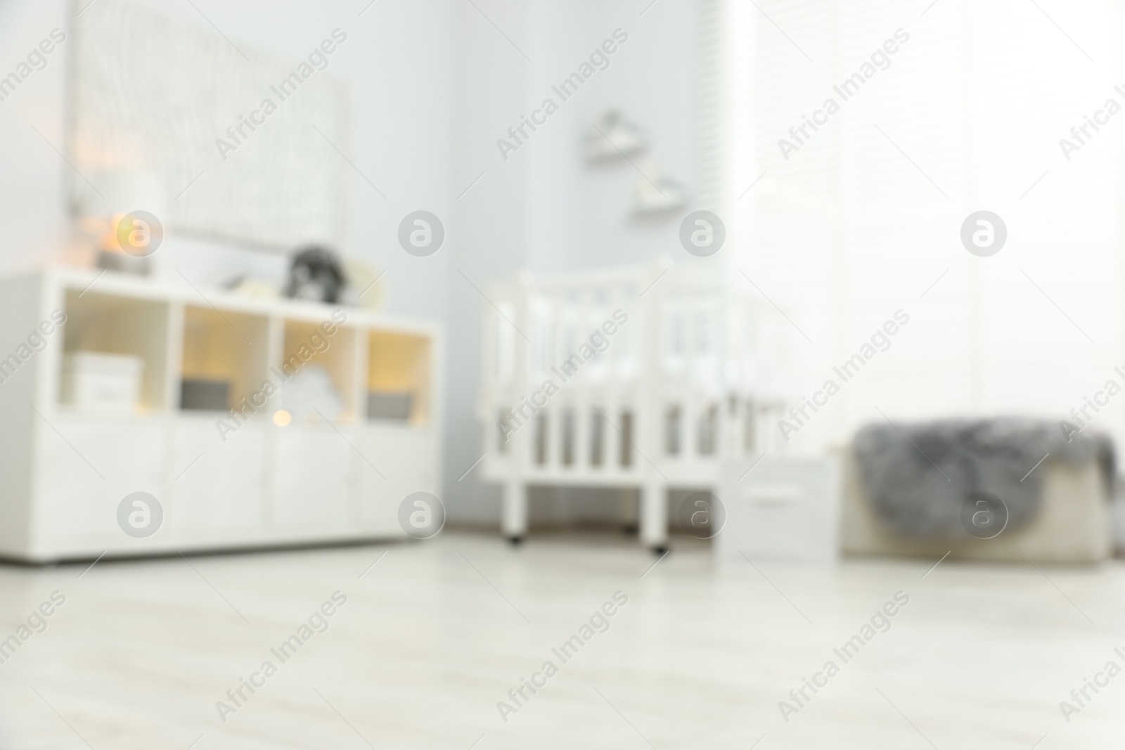 Blurred view of baby room interior with stylish crib and other furniture, low angle view Photo of Blurred view of baby room interior with stylish crib and other furniture, low angle view