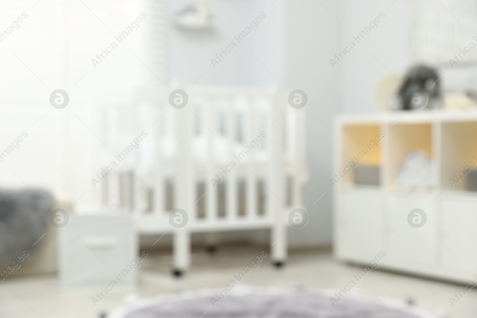 Baby room interior with stylish crib and other furniture, blurred view Photo of Baby room interior with stylish crib and other furniture, blurred view