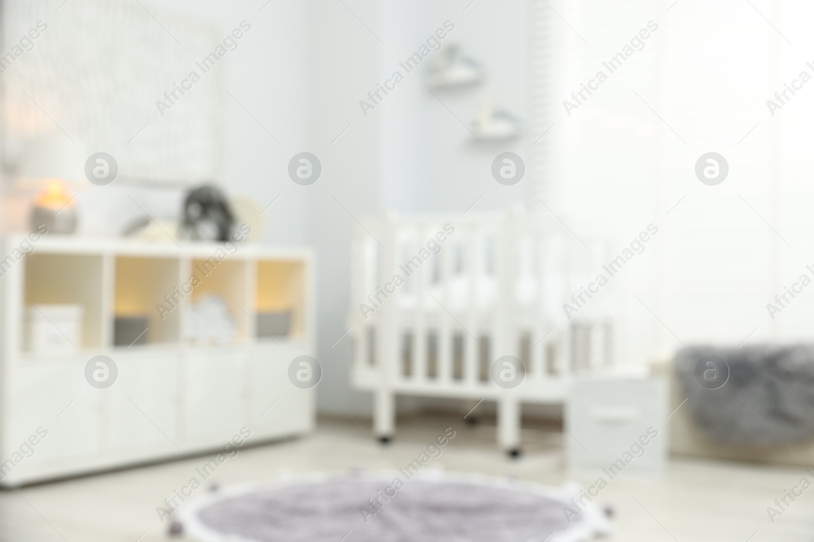 Baby room interior with stylish crib and other furniture, blurred view Photo of Baby room interior with stylish crib and other furniture, blurred view