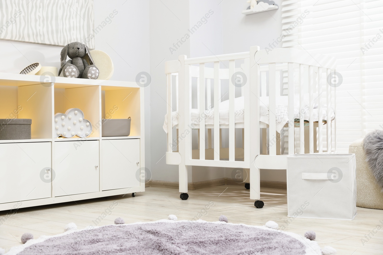 Beautiful baby room interior with stylish crib, other furniture and toys Photo of Beautiful baby room interior with stylish crib, other furniture and toys