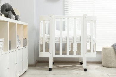 Photo of Beautiful baby room interior with stylish crib, other furniture and toys