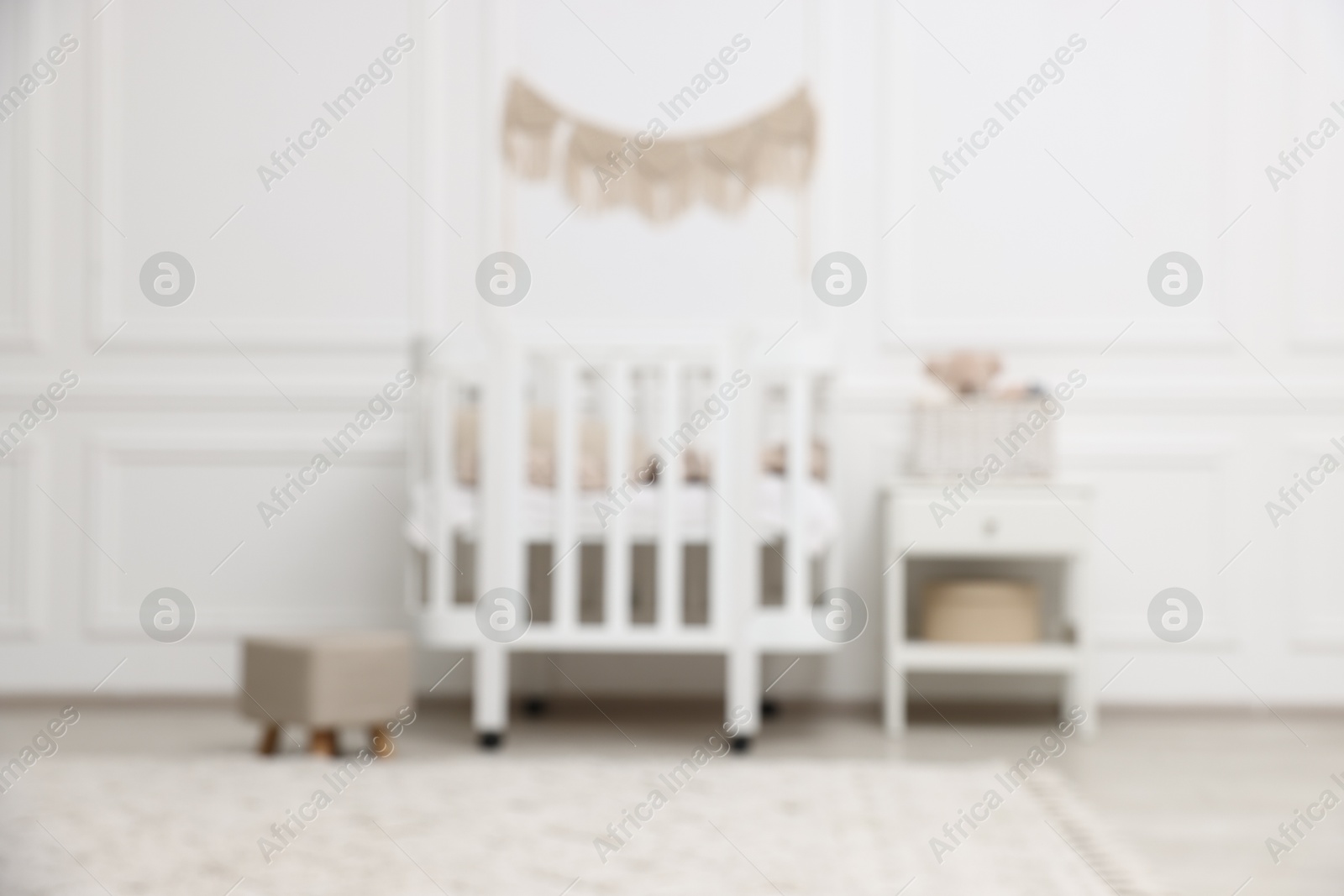 Photo of Blurred view of cozy baby room interior with comfortable crib
