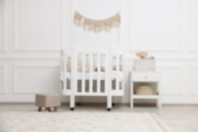Photo of Blurred view of cozy baby room interior with comfortable crib