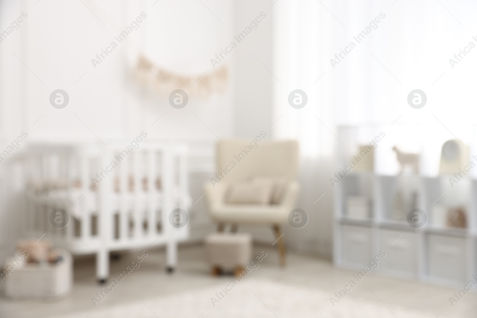 Baby room interior with crib and other furniture, blurred view Photo of Baby room interior with crib and other furniture, blurred view