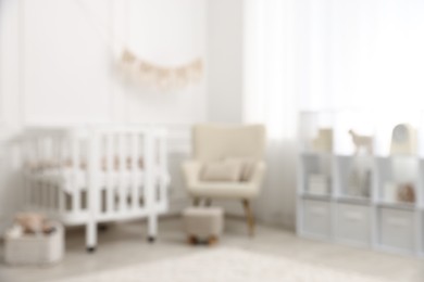 Photo of Baby room interior with crib and other furniture, blurred view